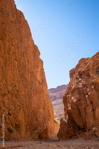 vertical view of the dramatic towering limestone cliffs of an empty Todra Gorge in Morocco under a clear blue sky