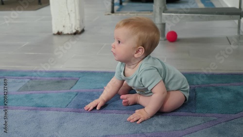 Infant transitions from sitting to crawling mobility. Curious baby moves on soft rug during developmental milestone. Young child in comfortable room demonstrates crawling