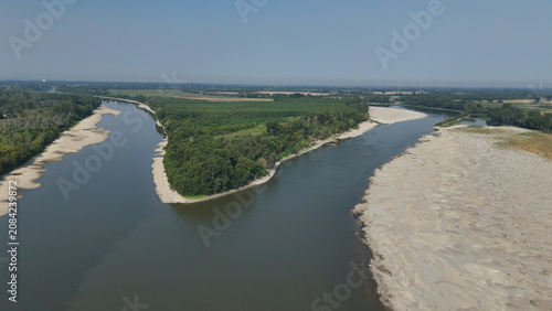 Po River experiencing extreme drought conditions during summer heatwave 2026, revealing vast dry riverbed expanses between Cremona and Piacenza, highlighting water crisis