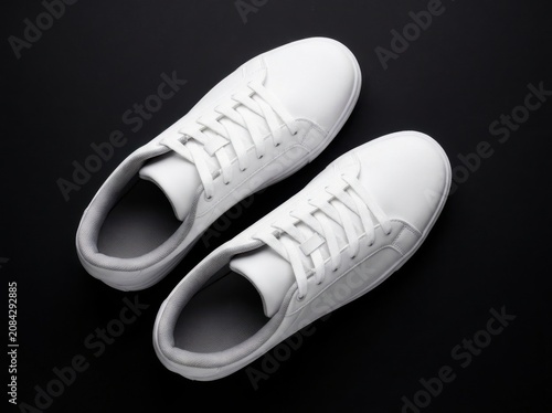 Pair of clean white sneakers isolated on black background