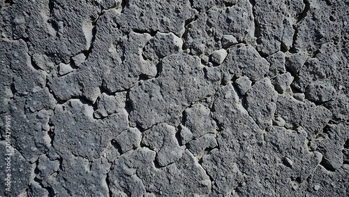 Close-up of rugged gray stone surface revealing intricate natural textures and depth.