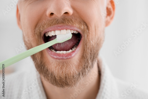 Young bearded man brushing ...