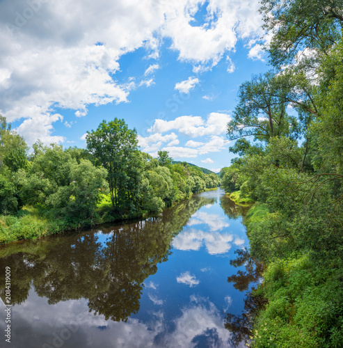 Obraz na płótnie pictorial wild landscape Schwarzer Regen river with reflecting clouds and blue s