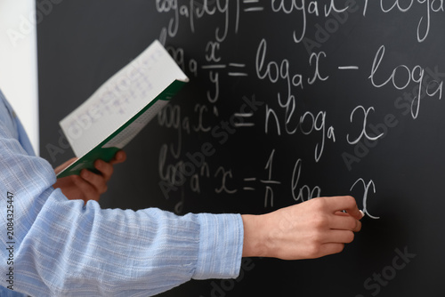 Female math teacher writing...