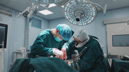 Wide view of an experienced surgical team performing a complex organ transplant procedure inside a modern operating room. Bright operating lights, sterile conditions, and coordinated teamwork 
