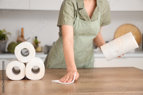 Young woman wiping table wi...