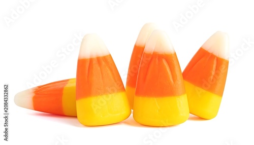 Pile of candy corn, traditional Halloween treat with distinct yellow, orange, and white layers, isolated on a white background