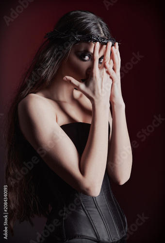 Studio portrait of beautiful goth girl. Sad informal (gothic) lady closing her face