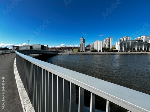 Railings of Bridge over the Vantaa River and Cityscape of Modern District in Helsinki, Finland.
