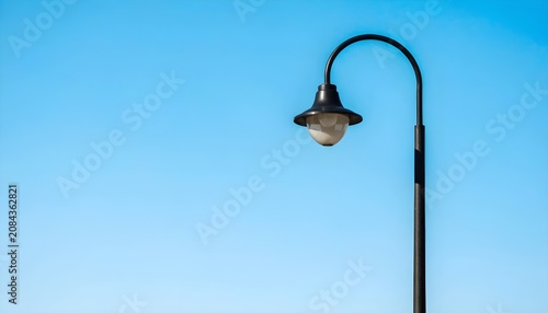 Classic Black Outdoor Wall Lantern Hanging on Clear Blue Sky Background Minimalist Style