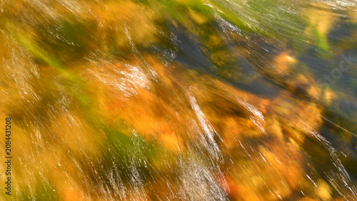 Obraz na plátně The flowing water against a brownish background creates a photograph that resembles an abstract painting