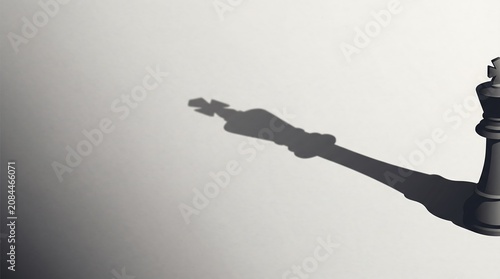 Black chess king piece casting a large shadow on white surface with strategy leadership minimalist competition business strength influence ambition planning intellectual decision challenge