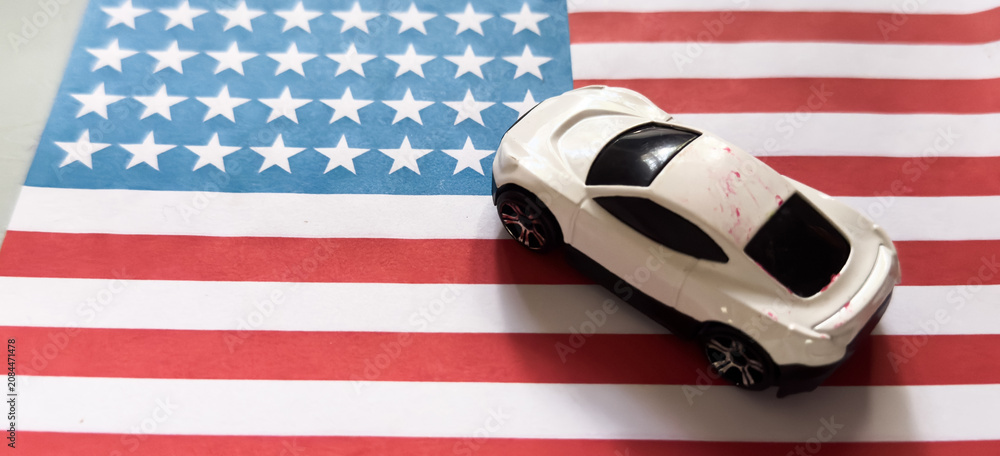 Obraz premium patriotic toy car resting on an american flag side view playful and colorful scene for children's toys educational resource web banner poster design visual story.
