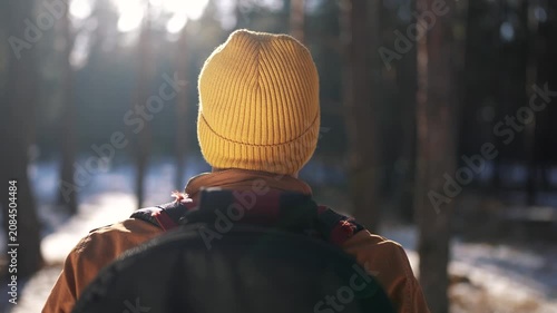 hiker with backpacks in slow motion walking silhouette in the glare of sun at sunset. tourist walk through the park and forest in winter. overcoming difficulties. teamwork concept close-up