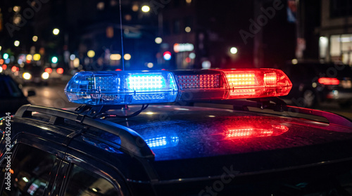 Red and Blue Emergency Flashing Lights on Police Patrol Car at Night