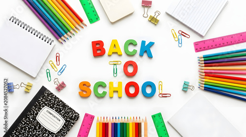 Colorful school supplies scattered on a white surface for back to school