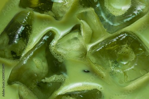 Macro Close-Up of Iced Japanese Matcha Latte with Crystal Clear Ice Cubes and Creamy Green Tea Texture