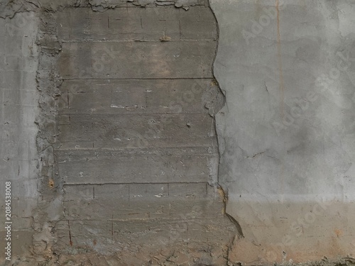 Obraz na plátne A close-up view of a damaged concrete wall with crumbling texture and exposed la