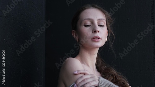 Konstfotografi Portrait of a beautiful young girl with bare shoulders on a dark studio background