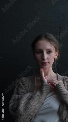 Portrait of a beautiful young girl on a dark studio background. Beautiful natural woman posing for the camera