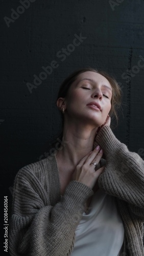Portrait of a beautiful young girl on a dark studio background. Beautiful natural woman posing for the camera