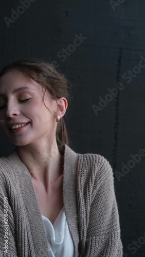 Portrait of a beautiful young girl on a dark studio background. Beautiful natural woman posing for the camera