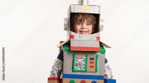 Young boy wearing a homemade cardboard robot costume with a big smile