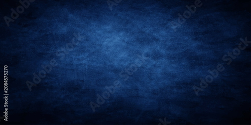 Foto Deep navy blue grunge texture background with intense central spotlight vignette