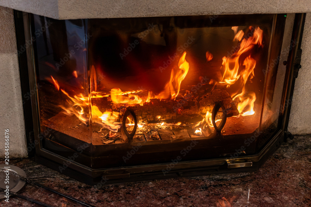 Fototapeta premium Fire in a fireplace in the living room with accessories