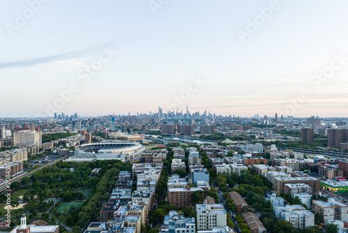 Фотография Wide aerial view over New York City skyline with dense residential blocks, stadi