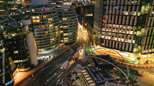 London business district buildings at night with red bus