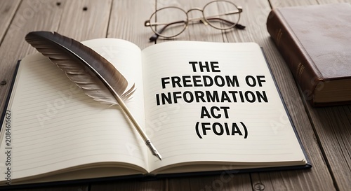 Vintage Freedom of Information Act FOIA text on open book, antique quill pen and glasses on wooden desk, legal transparency and government law concept