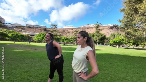 Two women warming up their muscles before a workout in a park