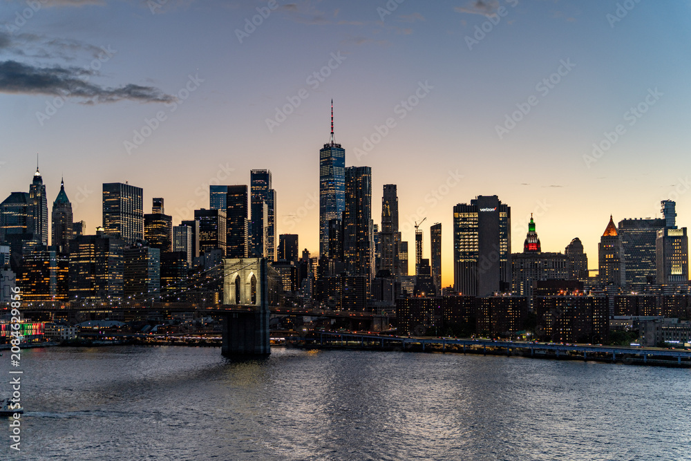 Obraz premium Sunset Skyline view of Lower Manhattan from an aerial view towards the Brooklyn Bridge and Financial District of New York City.
