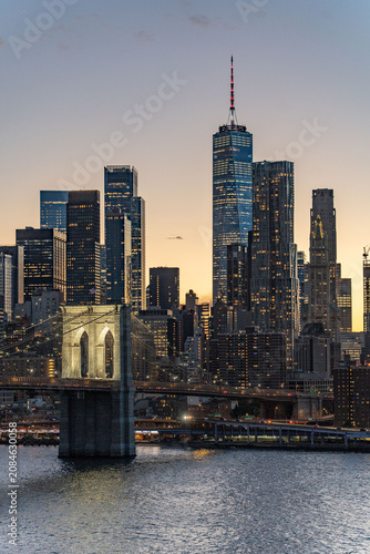 Bild auf Leinwand Sunset Skyline view of Lower Manhattan from an aerial view towards the Brooklyn Bridge and Financial District of New York City