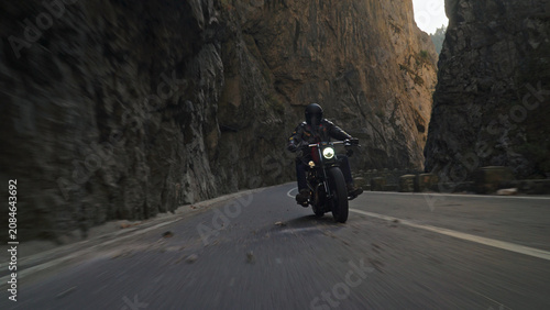 Biker riding motorcycle on winding canyon road