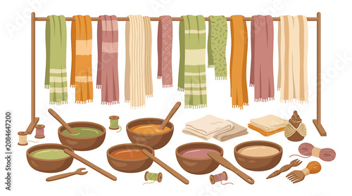 Traditional textile dyeing workshop with colorful fabrics hanging on rack and natural dye bowls.