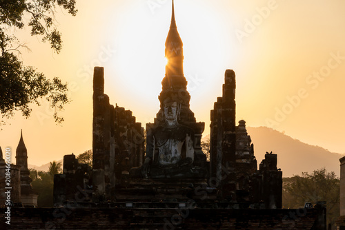 Fényképezés Ancient Buddha statue at Sukhothai Historical Park during sunset, Thailand