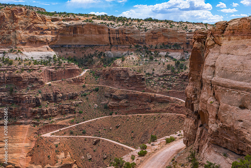 Slika na platnu Aerial view of a scenic switchback dirt road winding through deep red rock canyons and mesas in Canyonlands National Park