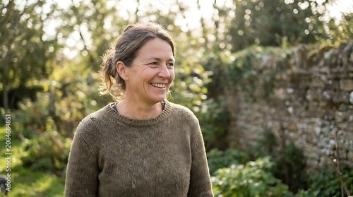 Smiling adult woman in knit sweater in natural garden