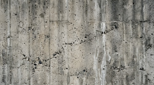 Raw weathered concrete wall with cracks and industrial surface texture