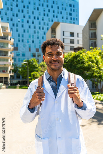 Foto Young black student wearing a lab coat and backpack
