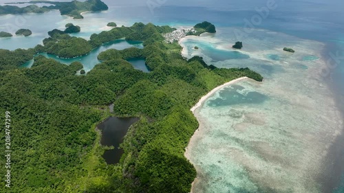 Top view of island coastline with green hills, sandy beaches and coastal lagoons. Sugba Blue Lagoon, Siargao, Philippines.