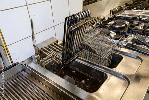 Commercial deep fryer with stacked frying baskets in professional restaurant kitchen