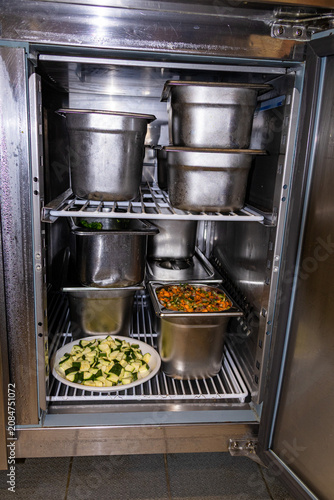 Open commercial oven with stockpots and prepared ingredients during restaurant service