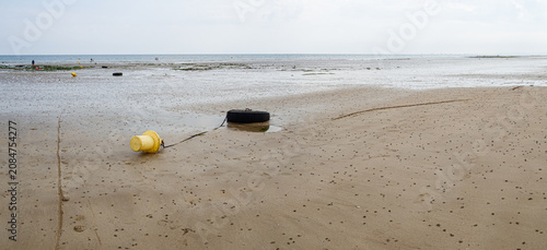 Detalle panorámico de una boya amarilla en la playa de Deauville, en la Normandía Francesa, histórica por su relación en la segunda guerra mundial, de vacaciones en verano de 2022