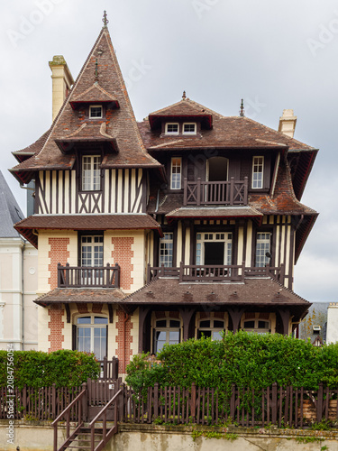 Vista de la fachada de casas lujosas con tejados puntiagudos y entramado de madera en la fachada en la Playa de Trouville-sur-Mer, viajando por la Normandía francesa en verano 2022