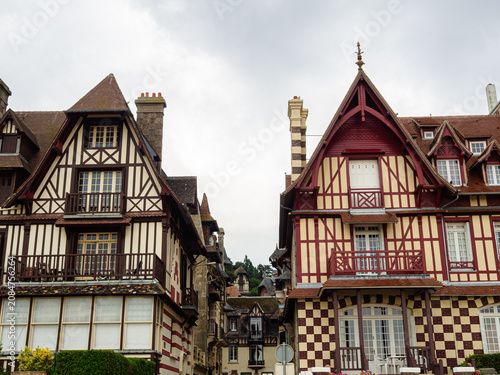 Vista de las casas de lujo en Playa de Trouville-sur-Mer, construcciones típicas de la Normandía Francesa con fachadas de entramados de madera y techos puntiagudos, viajando en verano de 2022