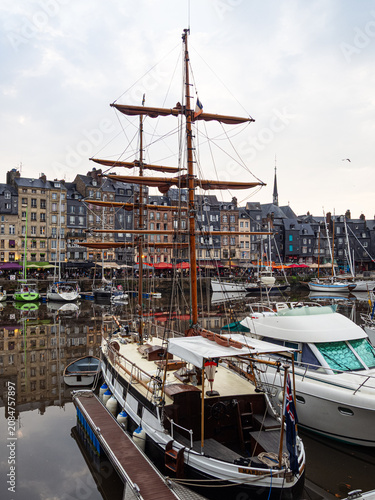 Vistas pintorescas del puerto de Honfleur, con barcos amarrados, veleros y edificios de colores reflejados en el agua, viajando por la Normandía de Francia en verano de 2022
