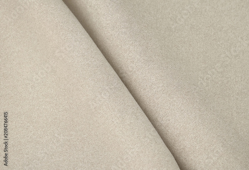 Elegant beige linen fabric texture with soft folds for a natural textile background surface